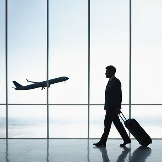 A man with a suitcase at an airport, ready for a new life with Migration service providers in Kerala.